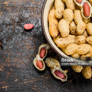 Peanuts in the bowl . On a Wooden background.